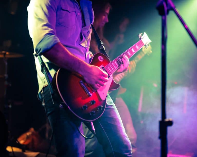 Close-up of a musician playing an electric guitar at a concert.