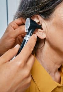 A woman has an otoscopic exam at Shoreline Hearing Center.